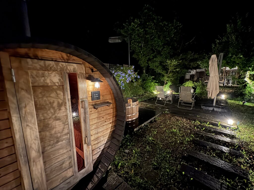 夜のバレルサウナ外観。樽型の建物と煙突