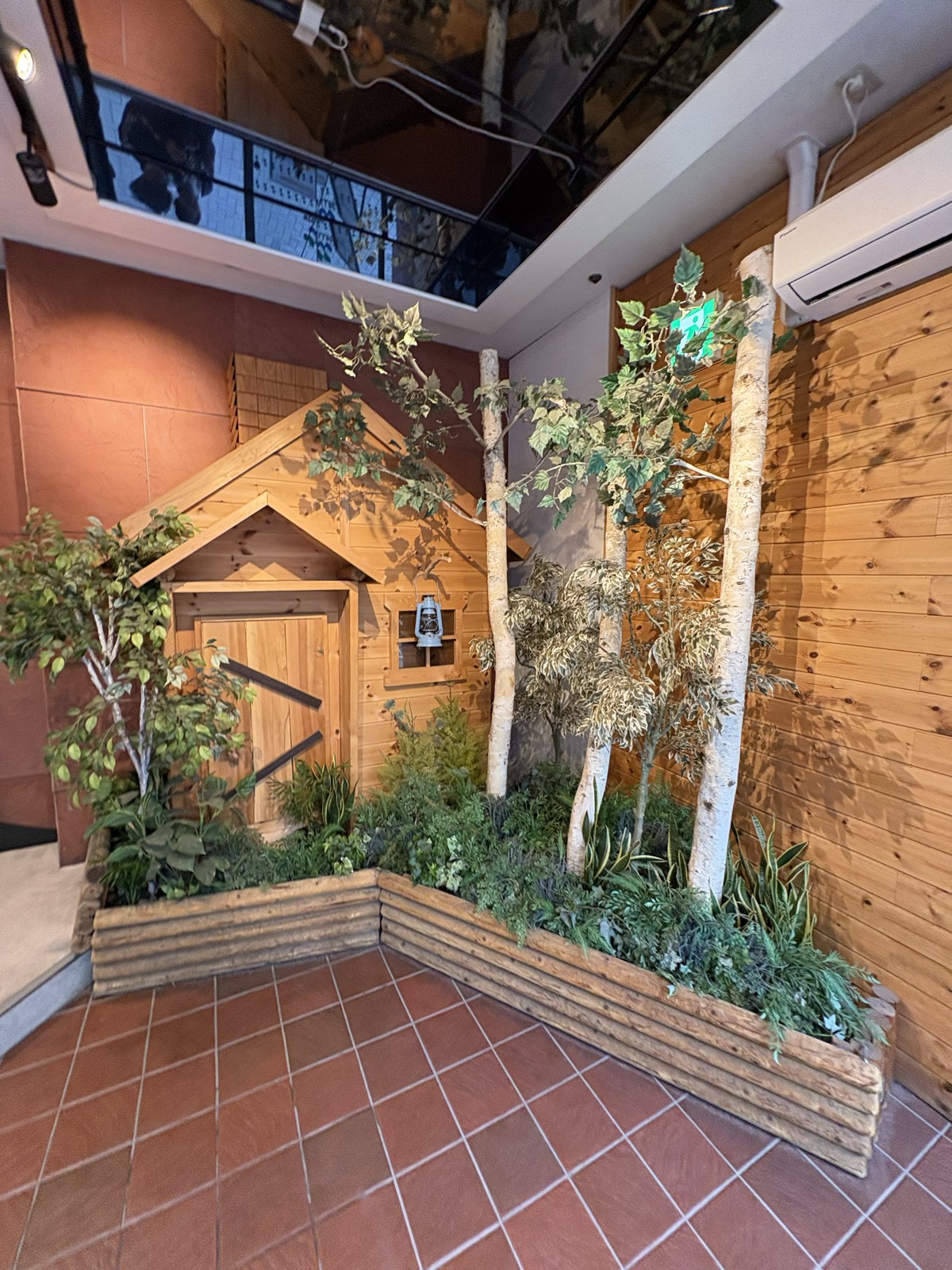 ウェルビー栄 入口横の植栽とサウナ小屋